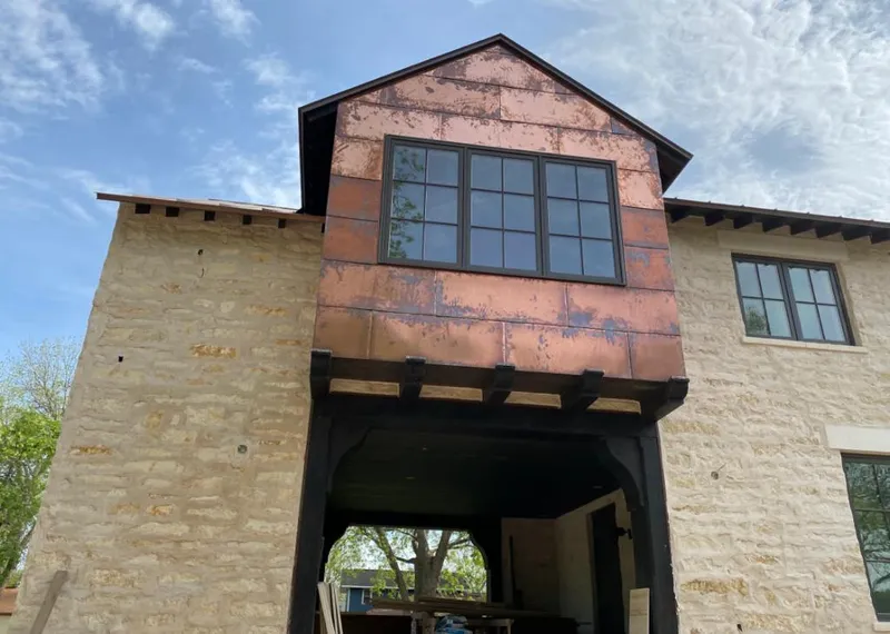 Copper metal panel facade on a stone building for Skylight Installation in Foley